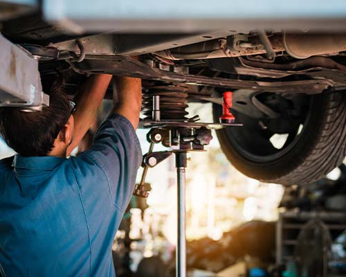 image of mechanic under car